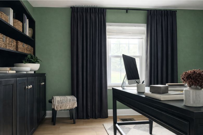 home office with green walls and grey curtains